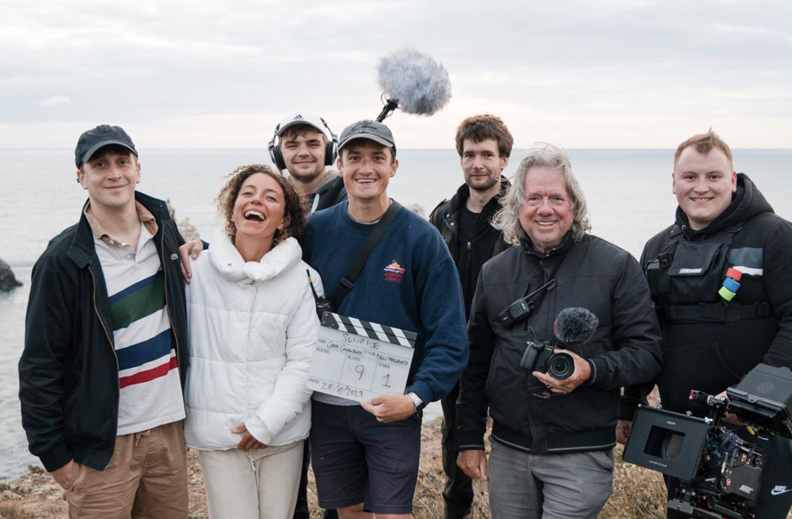 Cast and crew together on a coastal film set